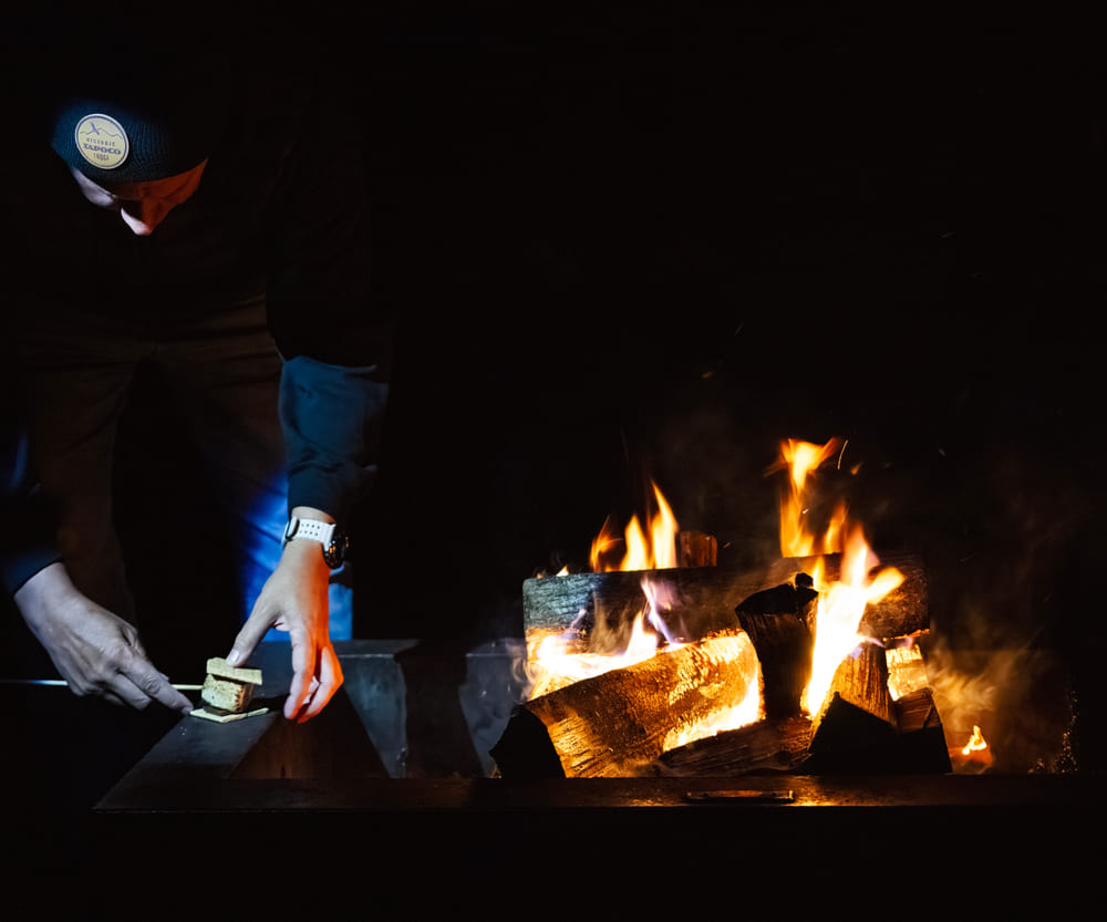A person at the fire table on the property at night